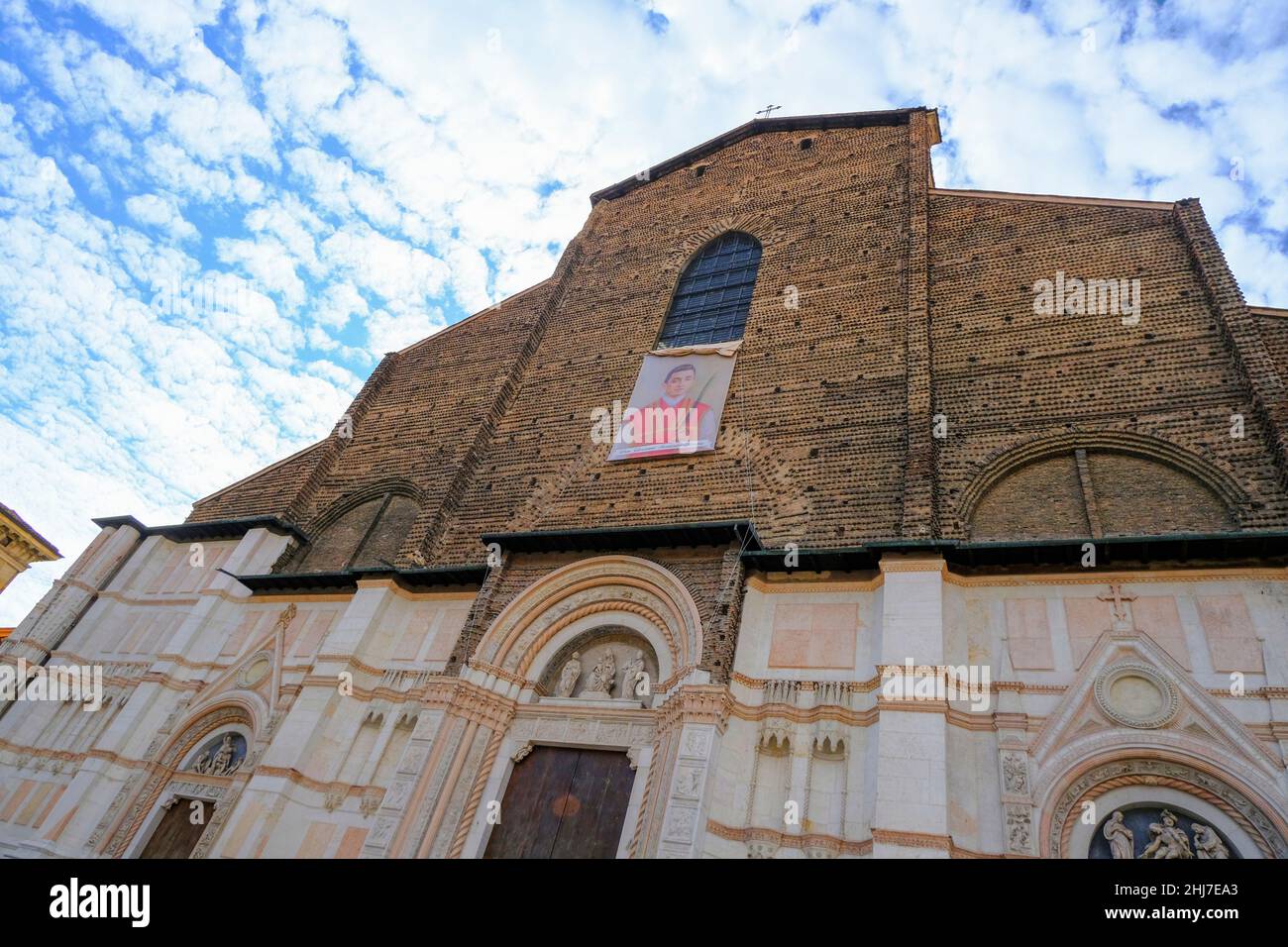 Facciata della basilica di San Petronio nella piazza, Piazza maggiore attraverso il cielo azzurro di Bologna Foto Stock