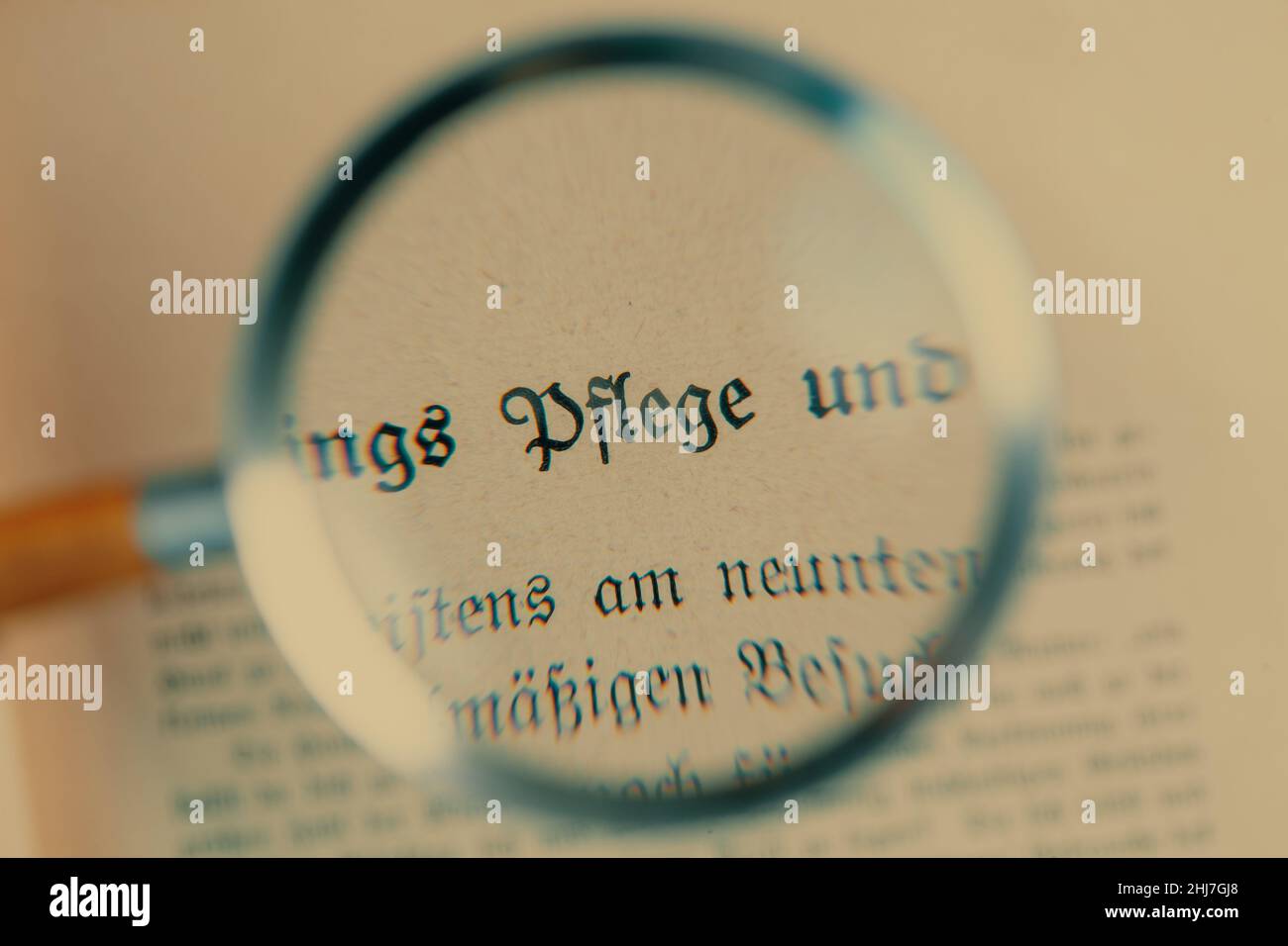 Lente d'ingrandimento sul documento di assicurazione vecchiaia in tedesco, l'iscrizione 'cura per gli anziani' concetto di pensione Foto Stock