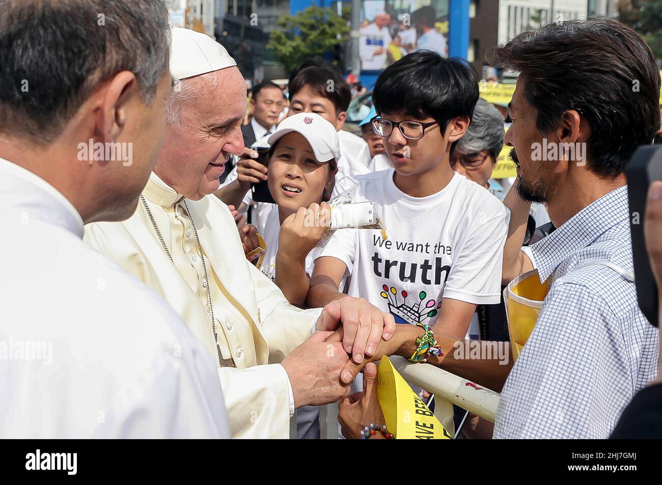 16 agosto 2014 - Seoul, Corea del Sud : Papa Francesco Motorcade con i fedeli cattolici del suo Popemobile al suo arrivo alla Santa Messa in piazza Gwanghwamun a Seoul il 16 agosto 2014. Sabato il papa ha celebrato un'enorme Messa all'aperto nel centro di Seoul, dove ha denunciato il crescente divario tra i haves e hanno dei not, esortando le persone nelle società benestanti ad ascoltare "il grido dei poveri" tra loro. Foto Stock