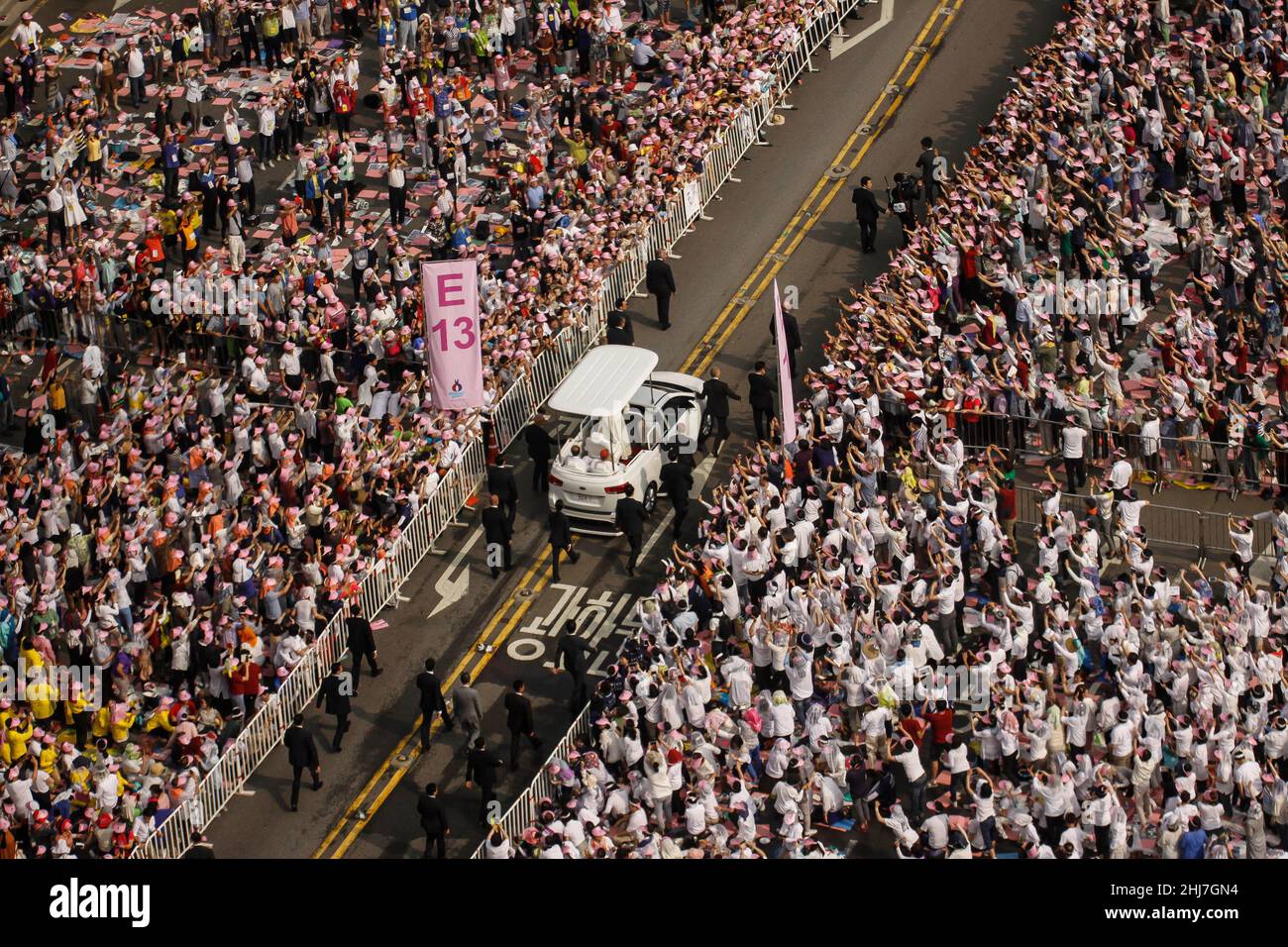 16 agosto 2014 - Seoul, Corea del Sud : Papa Francesco Motorcade con i fedeli cattolici del suo Popemobile al suo arrivo alla Santa Messa in piazza Gwanghwamun a Seoul il 16 agosto 2014. Sabato il papa ha celebrato un'enorme Messa all'aperto nel centro di Seoul, dove ha denunciato il crescente divario tra i haves e hanno dei not, esortando le persone nelle società benestanti ad ascoltare "il grido dei poveri" tra loro. Foto Stock