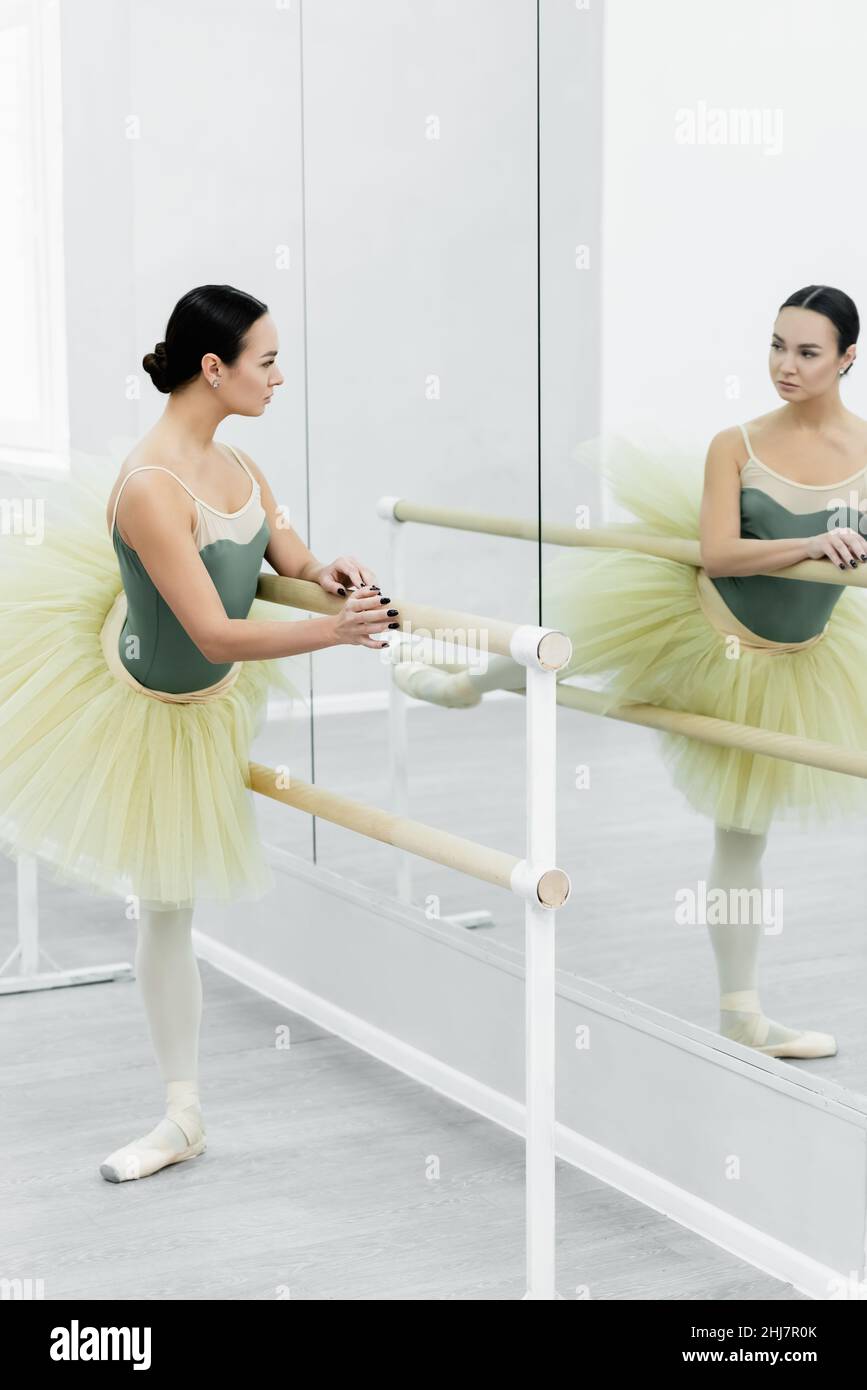 giovane ballerina che guarda nello specchio mentre si allunga a barre Foto  stock - Alamy