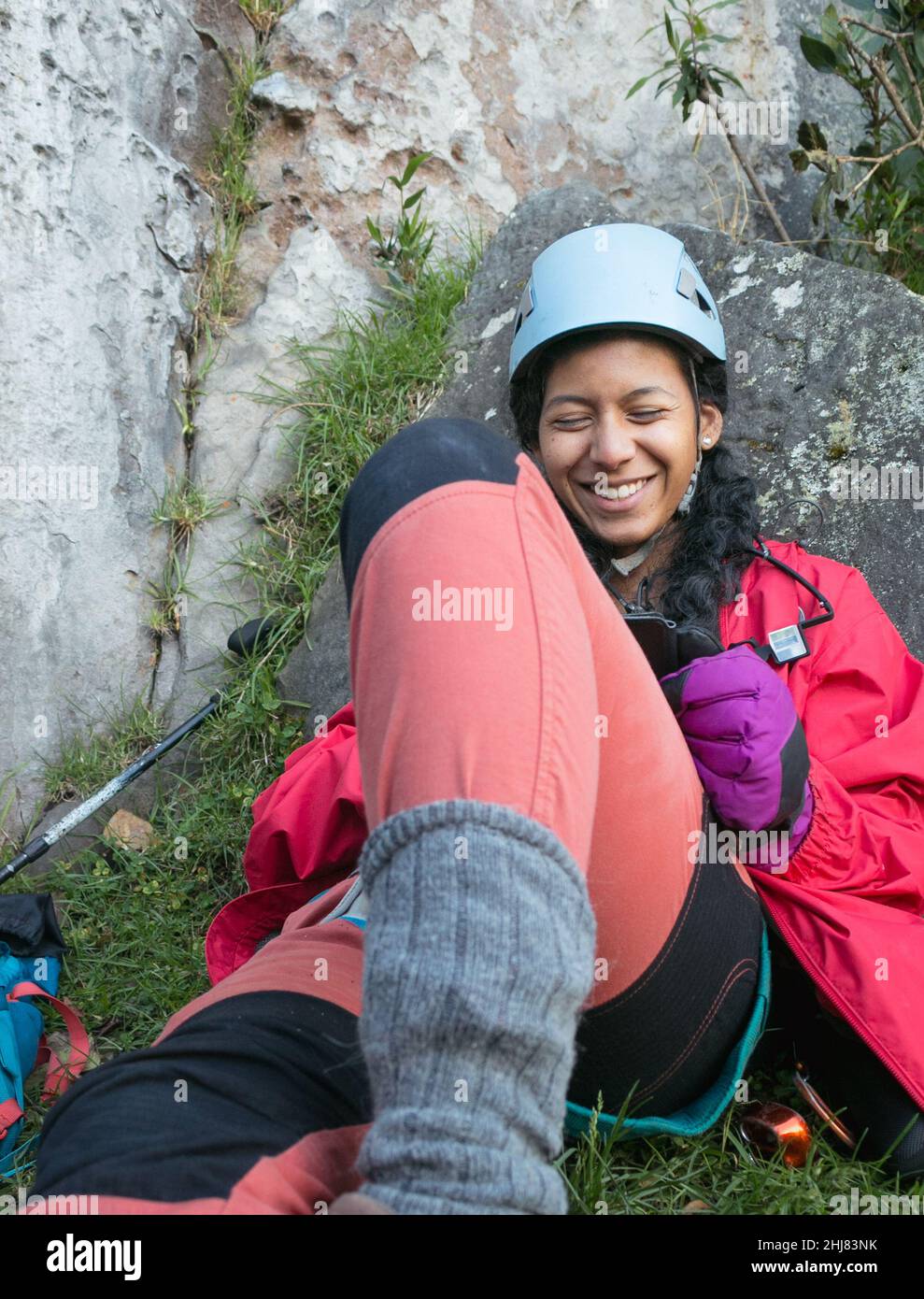Sorridente femmina rock climber legge all'aperto Foto Stock