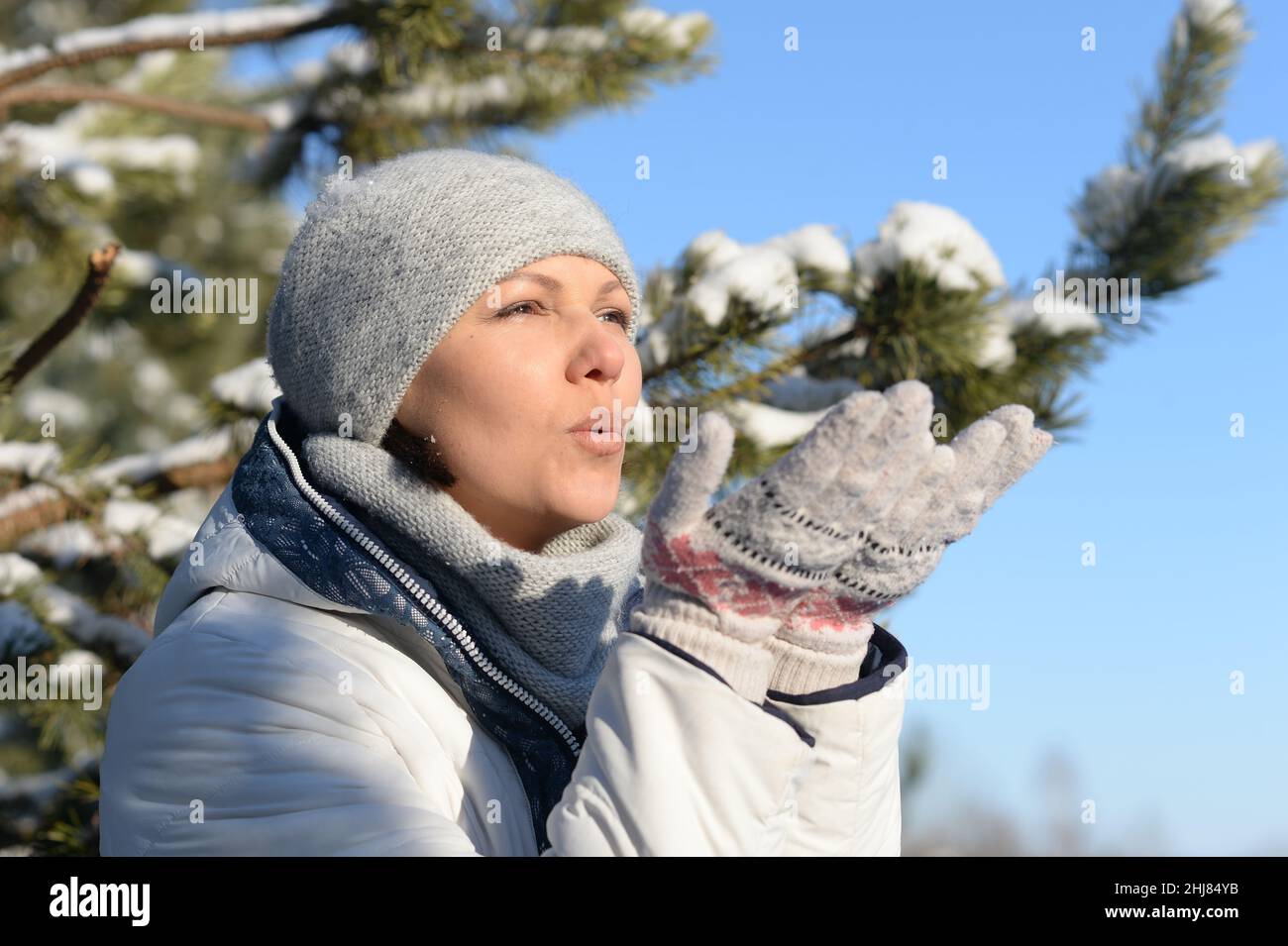 Giovane donna in inverno vestiti soffiando bacio Foto Stock