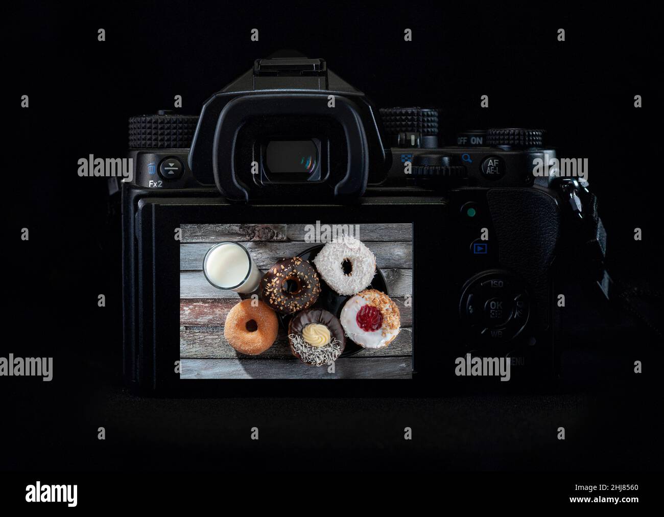 Immagine di ciambelle e un bicchiere di latte vista dall'alto in uno schermo lcd di una fotocamera DSLR o Mirrorless con luce sul bordo superiore, concetto di fotografia alimentare Foto Stock