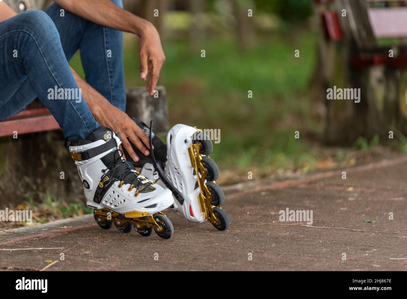 Close-up di giovane uomo a mettere su pattini a rotelle in linea Foto Stock