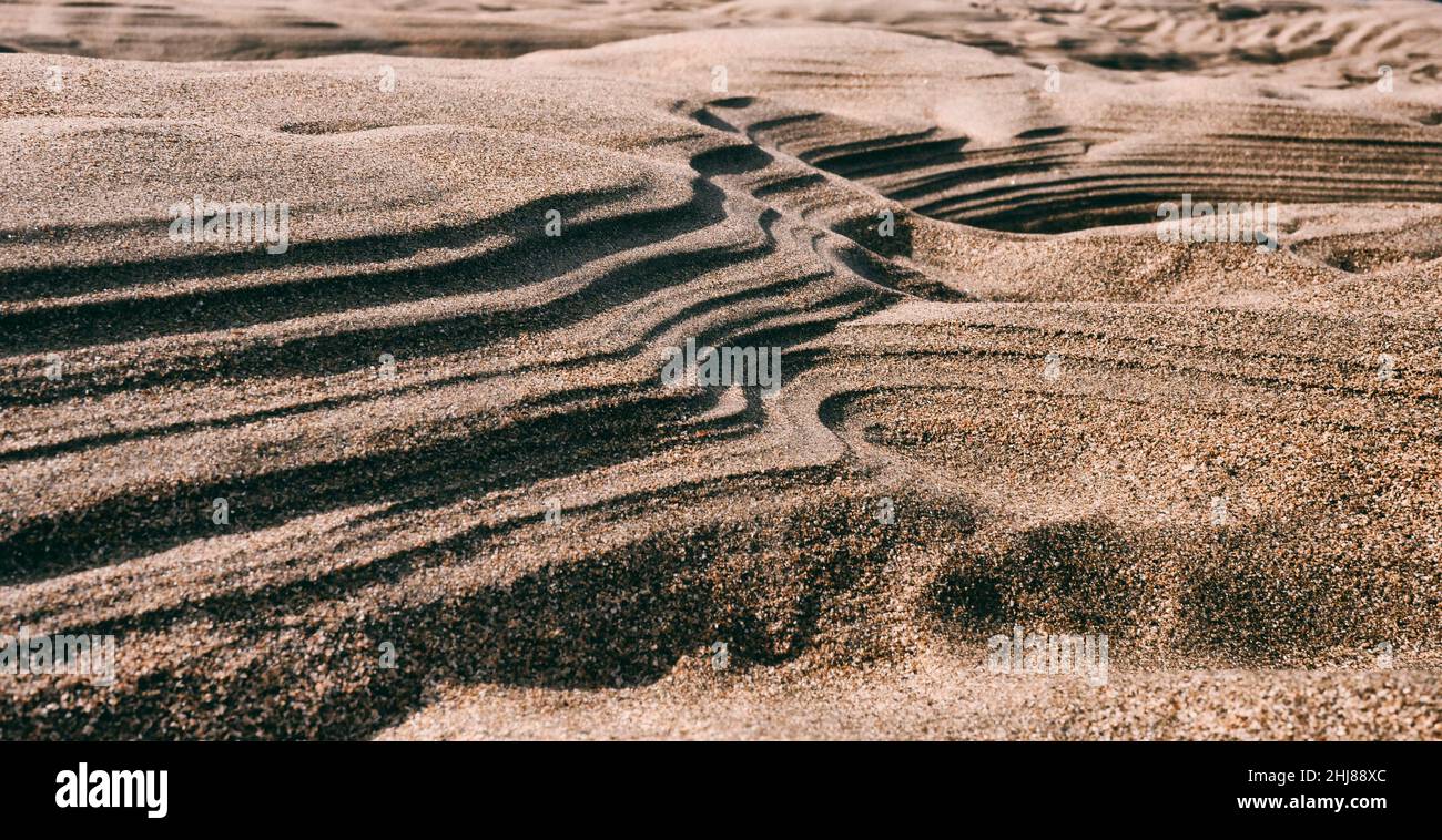 Forme inusuali fatte nella sabbia dal mare in ritirata. Foto Stock