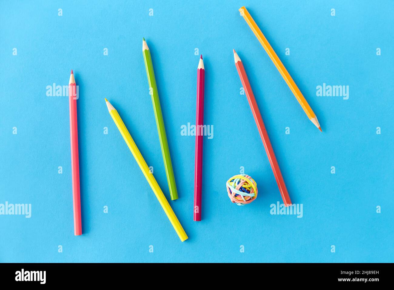 matite da colorare e fasce di gomma su blu Foto Stock