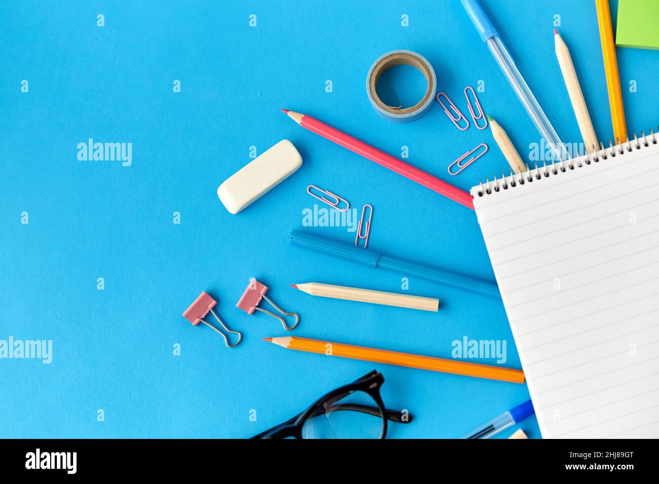 forniture per notebook e scuole su sfondo blu Foto Stock