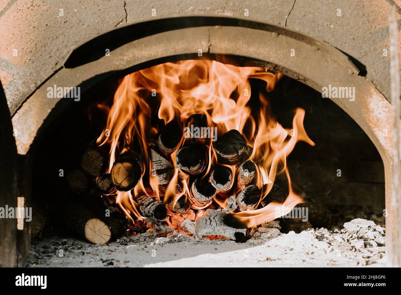 Primo piano di barbecue, pizza fatta in casa, mettendo la pizza nel forno a legna per cuocere Foto Stock
