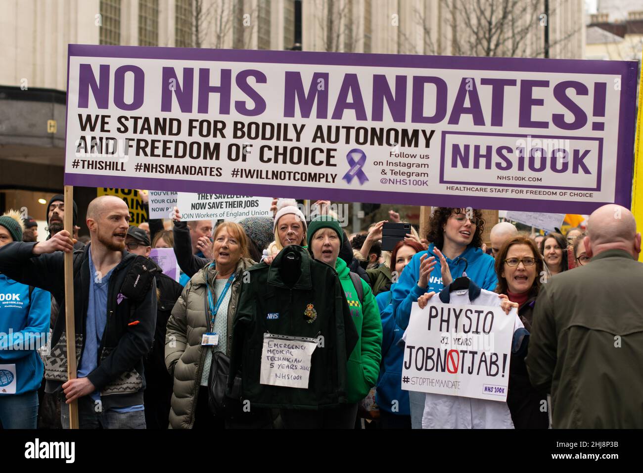 Contro Vax protesta Deansgate. Testo banner No NHS Mandati. Fisioterapista e tecnico medico di emergenza che tiene uniforme. Manchester Regno Unito Foto Stock