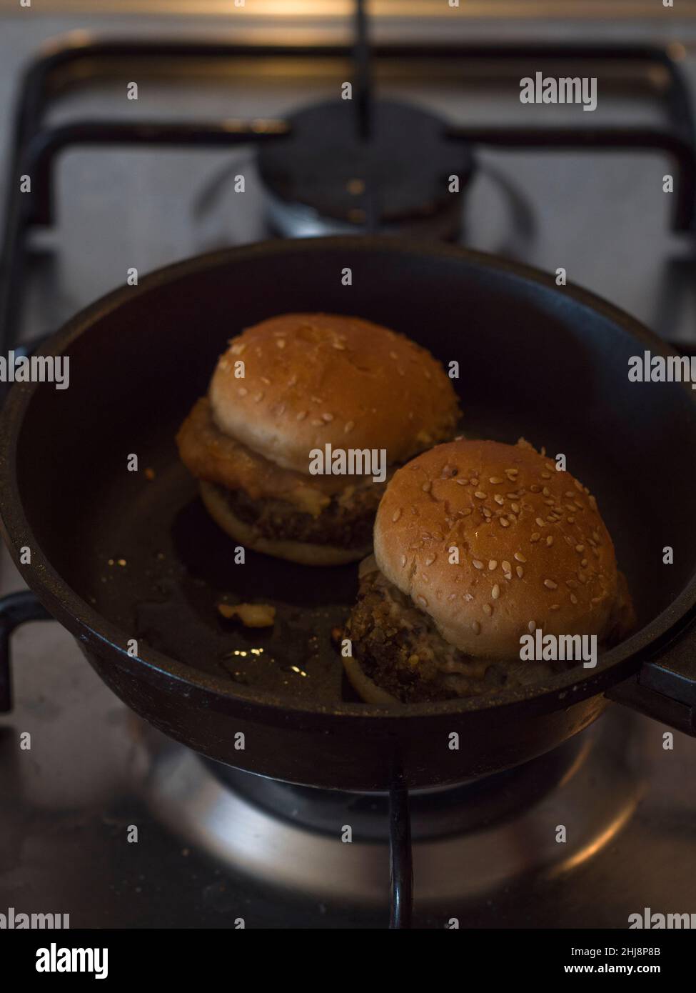 Vista verticale dei mini hamburger vegetariani riscaldati in una padella. Foto Stock
