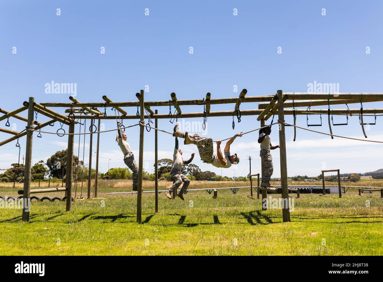 Gruppo di uomini e donne diversi soldati corda arrampicata durante il corso di ostacoli al campo di stivali Foto Stock