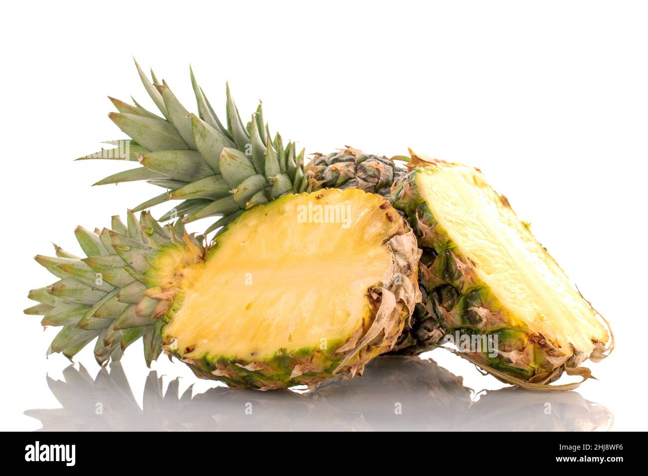 Un ananas maturo tagliato a metà e uno intero, primo piano, isolato su bianco. Foto Stock