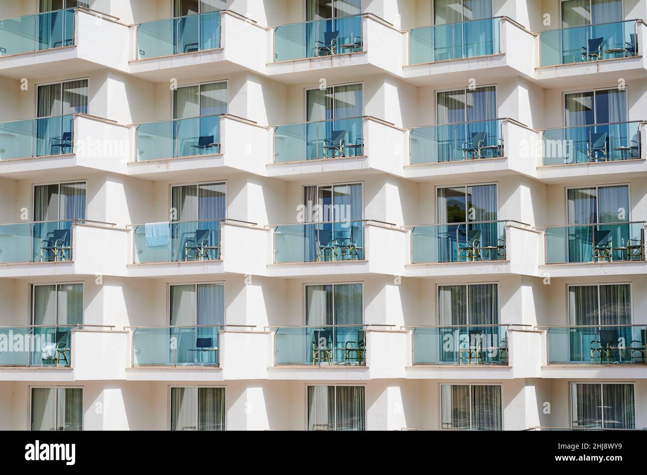 le camere dell'hotel dispongono di balconi con sedie in una giornata di sole Foto Stock