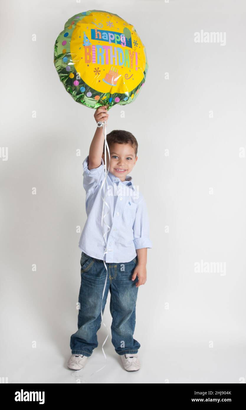 ragazzino che tiene in mano la sua mongolfiera di compleanno Foto Stock