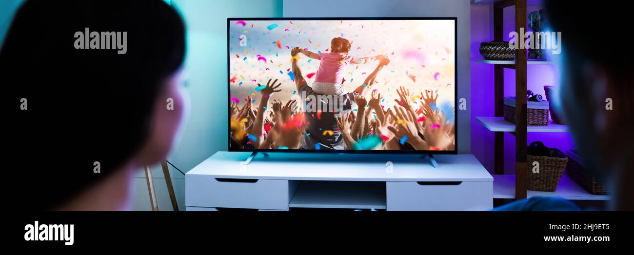 Coppia di famiglia che guarda la TV o il film sul divano Foto Stock