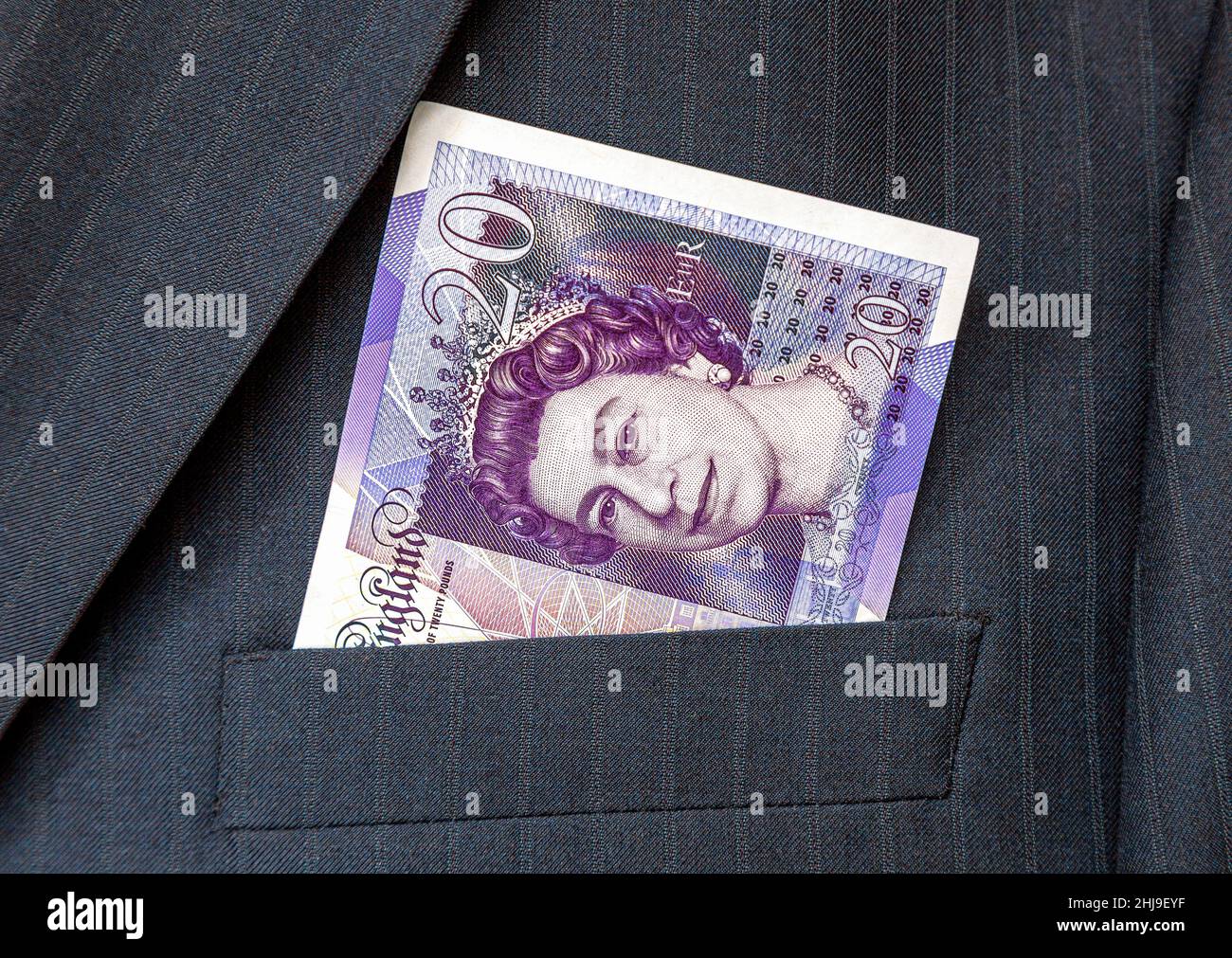Banconote di sterline britanniche che sporgono dalla tasca del vestito dell'uomo d'affari. Soldi in tasca del vestito di affari Foto Stock