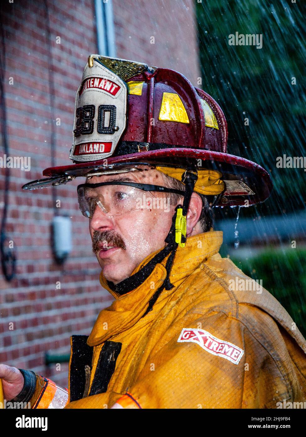 I vigili del fuoco perforano l'impianto sprinkler nel dispositivo di estrazione Foto Stock