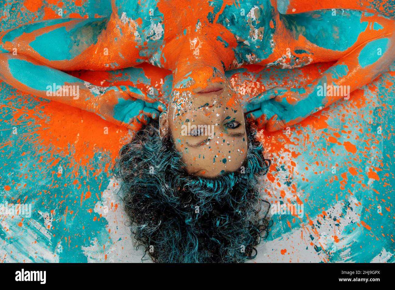 singolare notevole impressionante ritratto di donna ricurly bruna adulta, punti di verde turchese e colore arancione vernice, decorativo creativo espressivo a Foto Stock