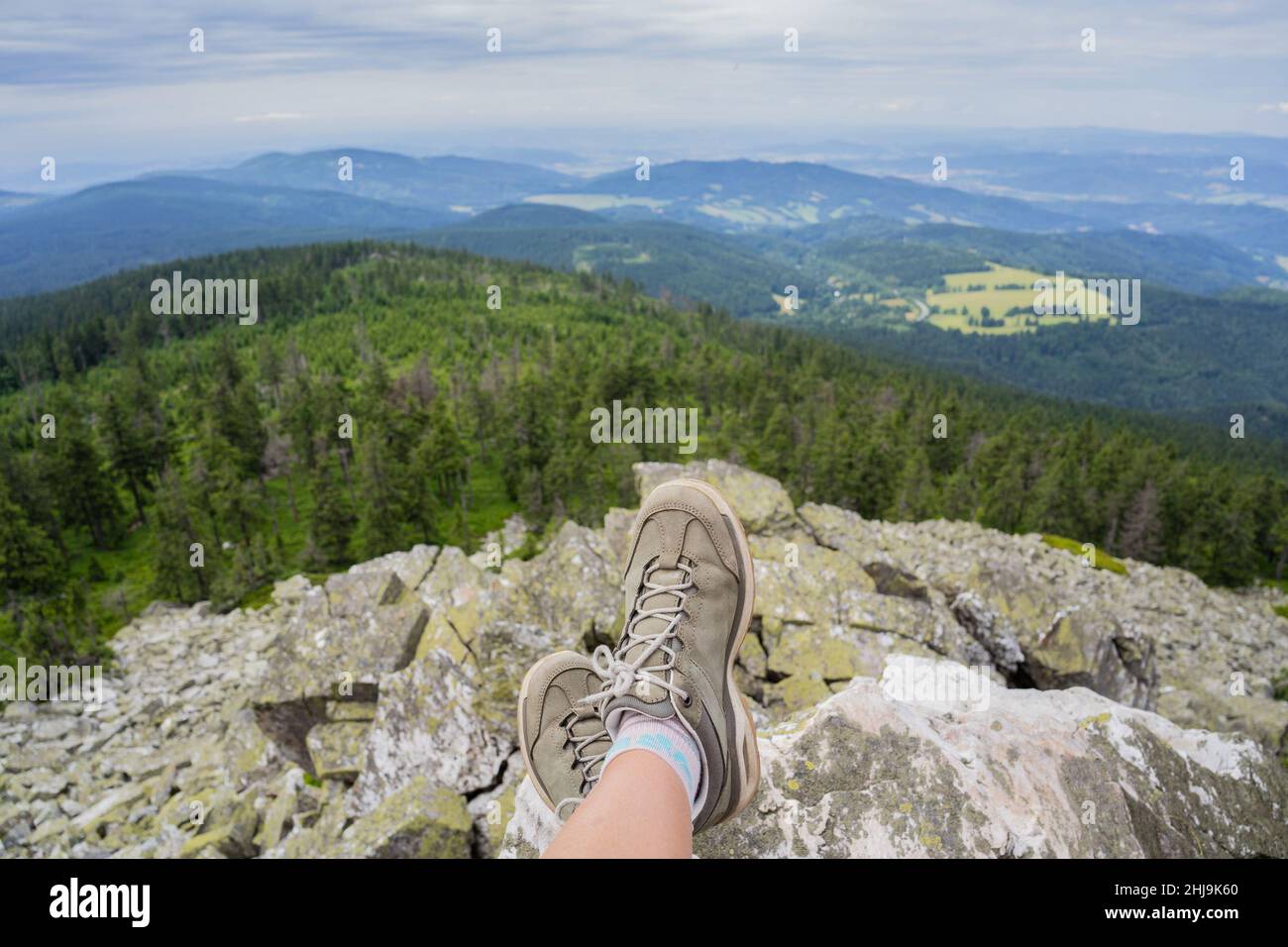 Gambe di donna viaggiatore seduto su alto Rocks.Freedom Wanderlust viaggio concept.Trekking stivali contro bella paesaggio.meraviglioso mozzafiato Foto Stock