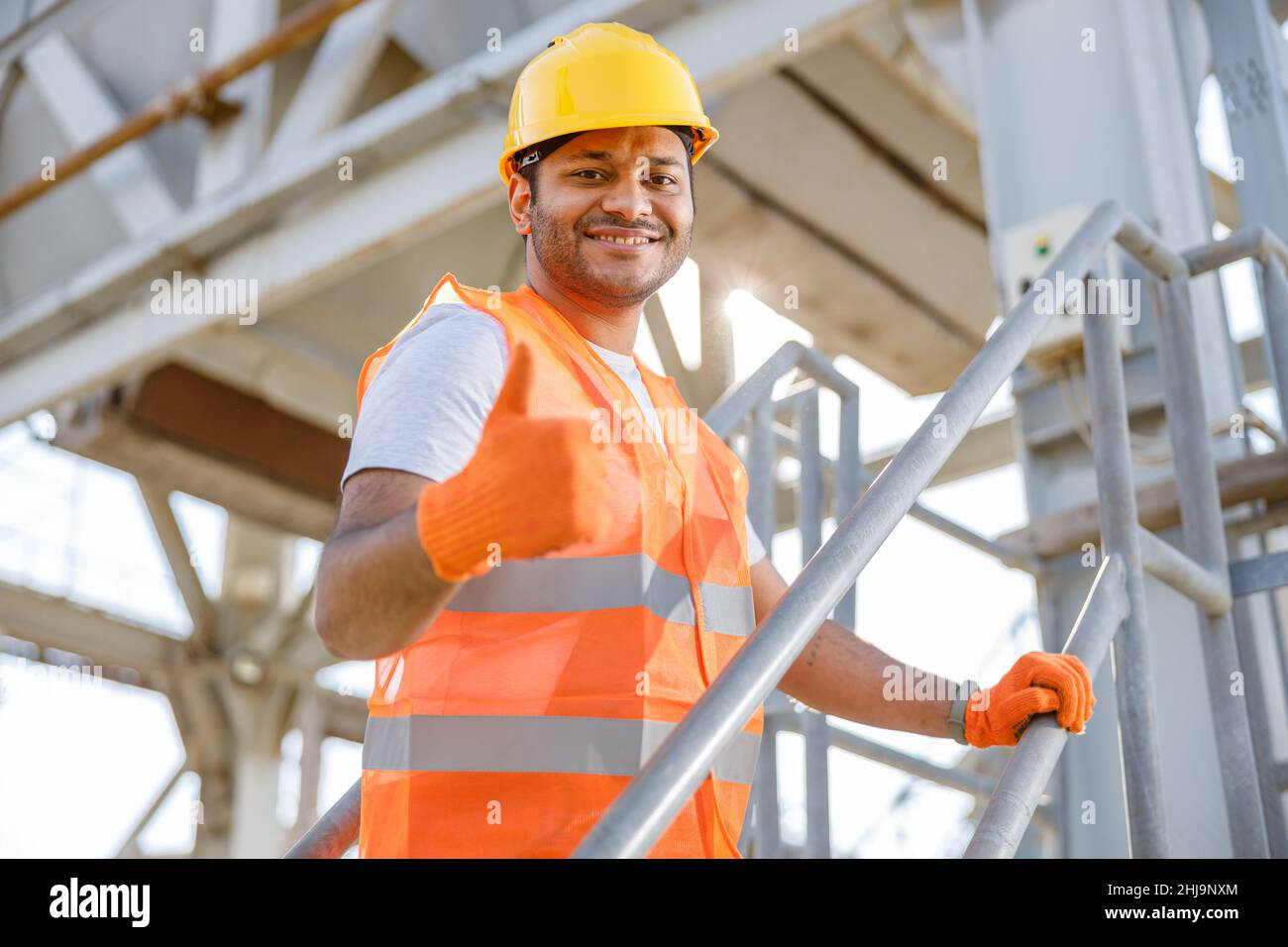 Sorridente giovane uomo che lavora in cantiere Foto Stock