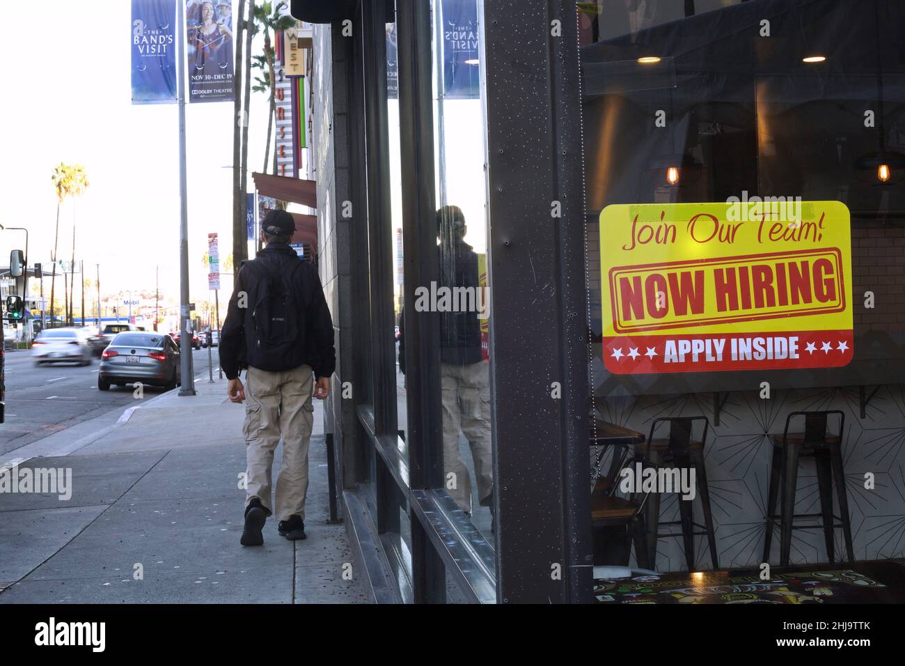 Un uomo cammina oltre un cartello Now Hiring su Sunset Boulevard Foto Stock
