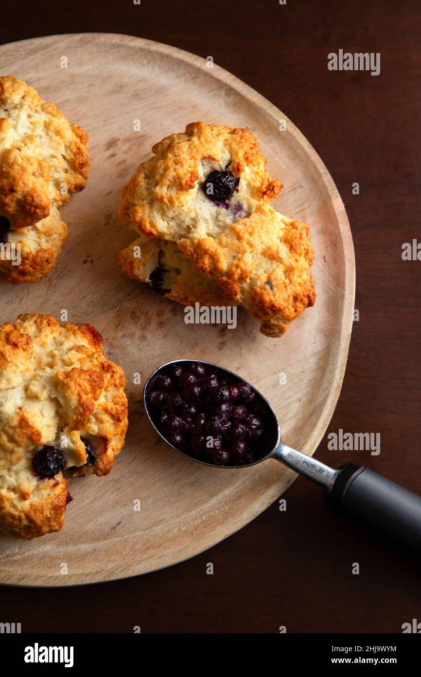 Una colazione a base di dolci focaccine di mirtillo posto su un rustico piatto di legno. Foto Stock