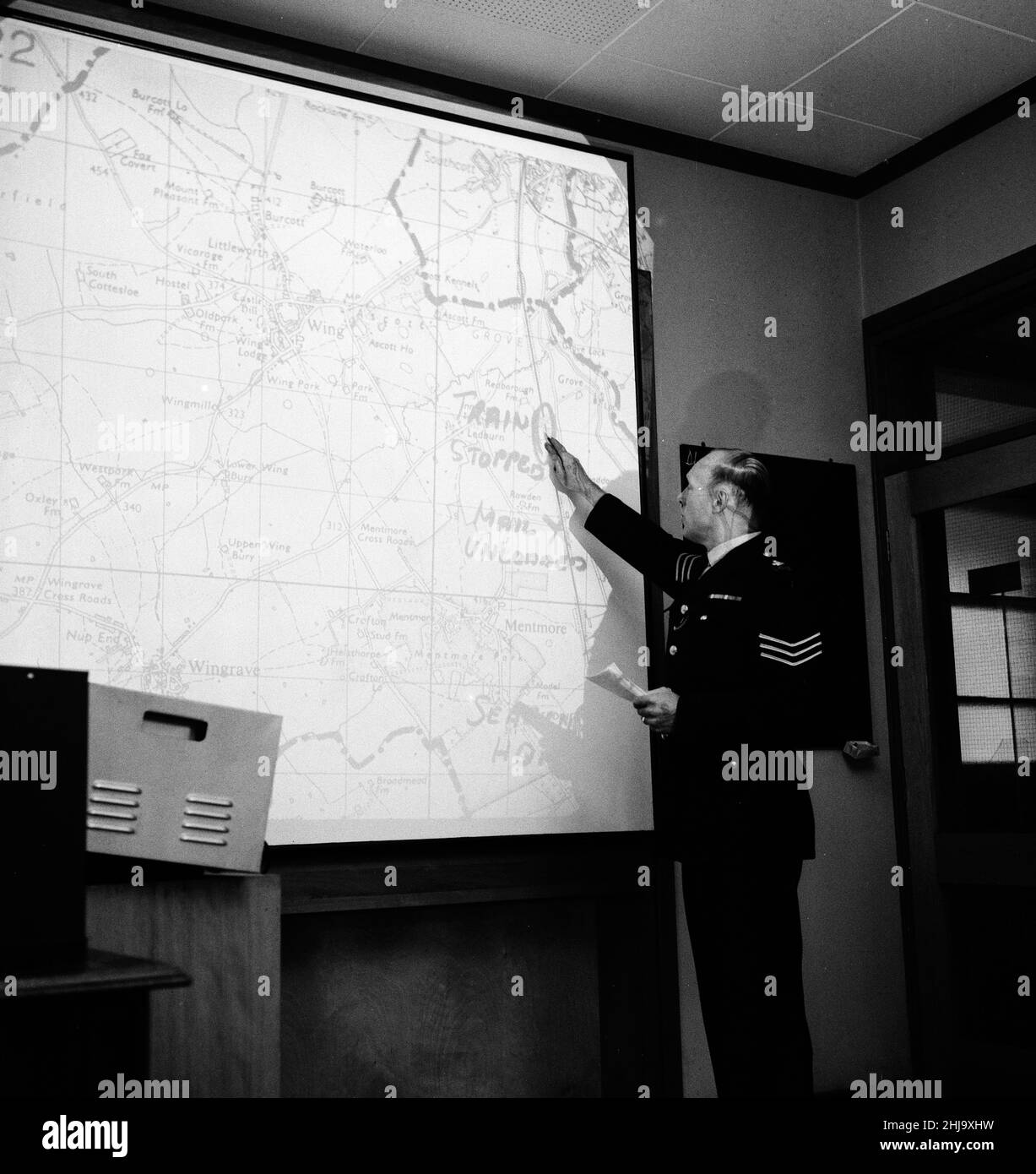 La sede centrale della polizia di Aylesbury, Buckinghamshire, all'interno della stanza di controllo della sede centrale della polizia come caccia al manhunt per il grande Gang della posta continua, lunedì 12th agosto 1963. La nostra immagine mostra ... mappa illuminata di scena rapina è proiettata su grande schermo. Il 1963 Great Train Robbery fu la rapina di £2,6 milioni da un treno Royal Mail diretto da Glasgow a Londra sulla West Coast Main Line nelle prime ore del 8th agosto 1963, a Bridego Railway Bridge, Ledburn, vicino Mentmore nel Buckinghamshire, Inghilterra. Foto Stock