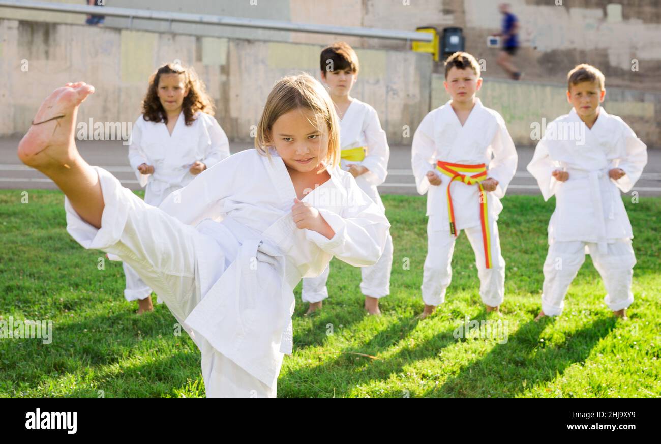 Ragazza in kimono in posa durante l'allenamento all'aperto Foto Stock