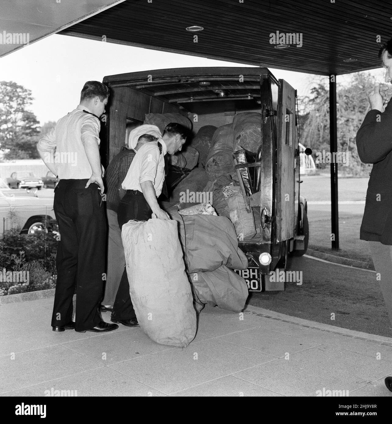 La polizia scarica le buste postali dalla fattoria presso la sede centrale della polizia di Aylesbury nel Buckinghamshire, mercoledì 14th agosto 1963. Il 1963 Great Train Robbery fu la rapina di 2,6 milioni di sterline da un treno Royal Mail diretto da Glasgow a Londra sulla West Coast Main Line nelle prime ore del 8th agosto 1963, a Bridego Railway Bridge, Ledburn, vicino a Mentmore nel Buckinghamshire, Inghilterra. Foto Stock