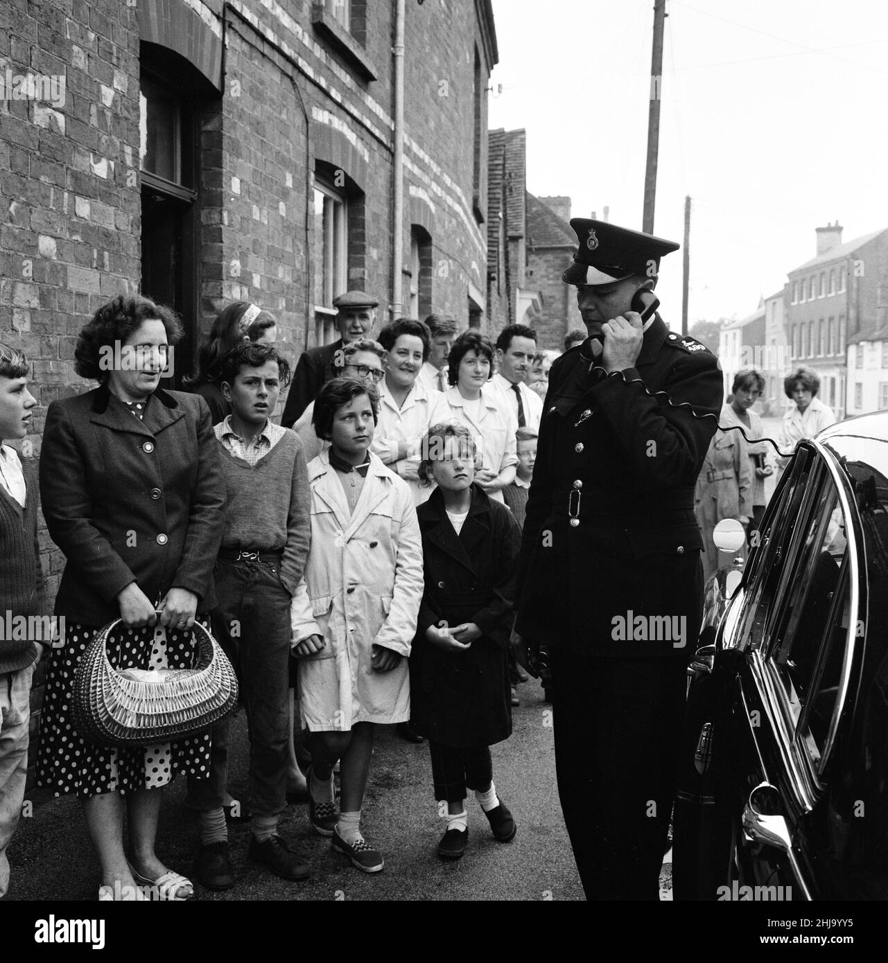 Auto di polizia dotata di un telefono altoparlante unità, appello per informazioni nel villaggio di Brill, Mercoledì 14th agosto 1963. Il 1963 Great Train Robbery fu la rapina di 2,6 milioni di sterline da un treno Royal Mail diretto da Glasgow a Londra sulla West Coast Main Line nelle prime ore del 8th agosto 1963, a Bridego Railway Bridge, Ledburn, vicino a Mentmore nel Buckinghamshire, Inghilterra. Foto Stock