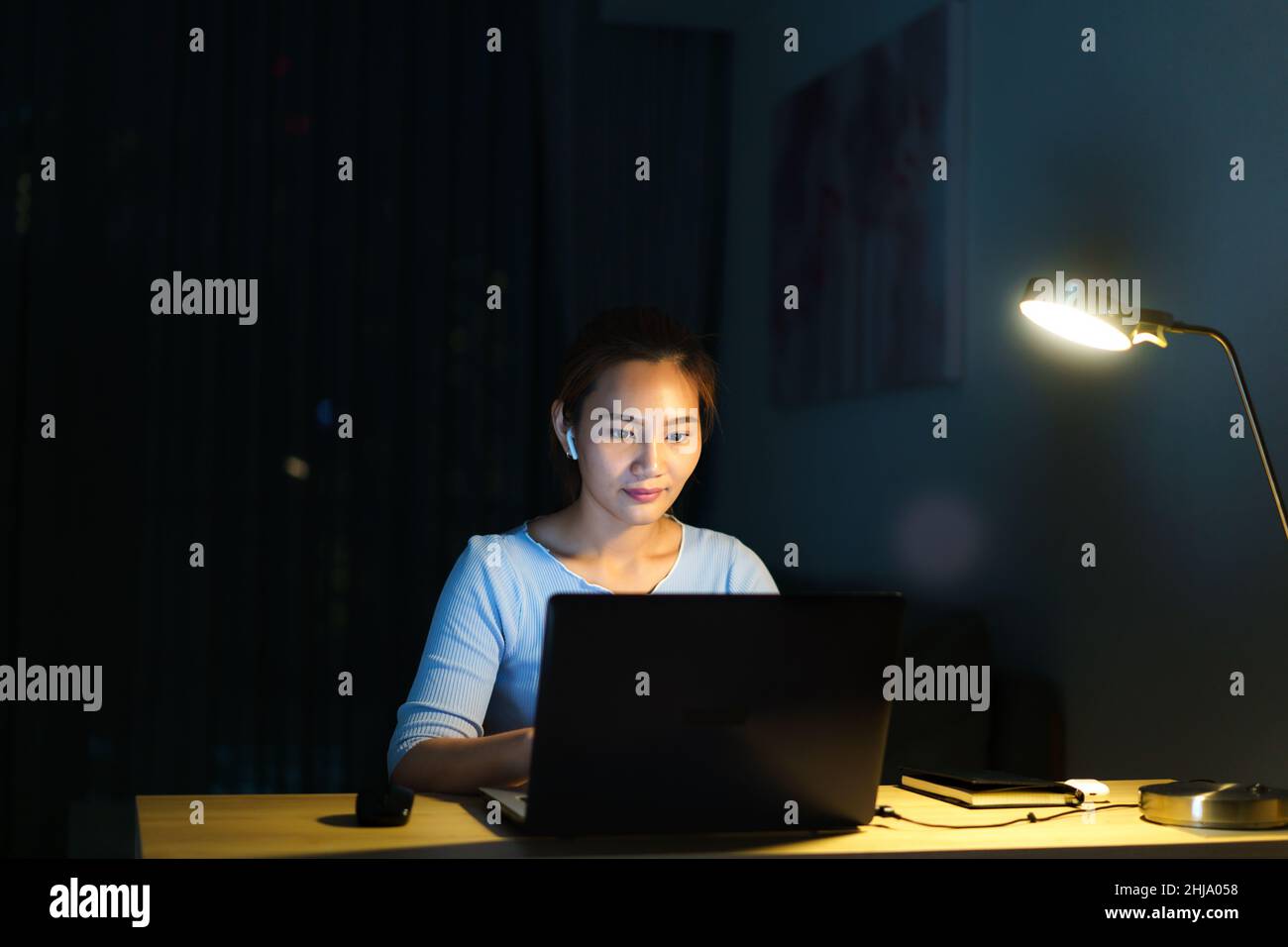 Le donne asiatiche lavorano a casa sono sedute al lavoro con colleghi o manager tramite videochiamata di notte a casa. Foto Stock