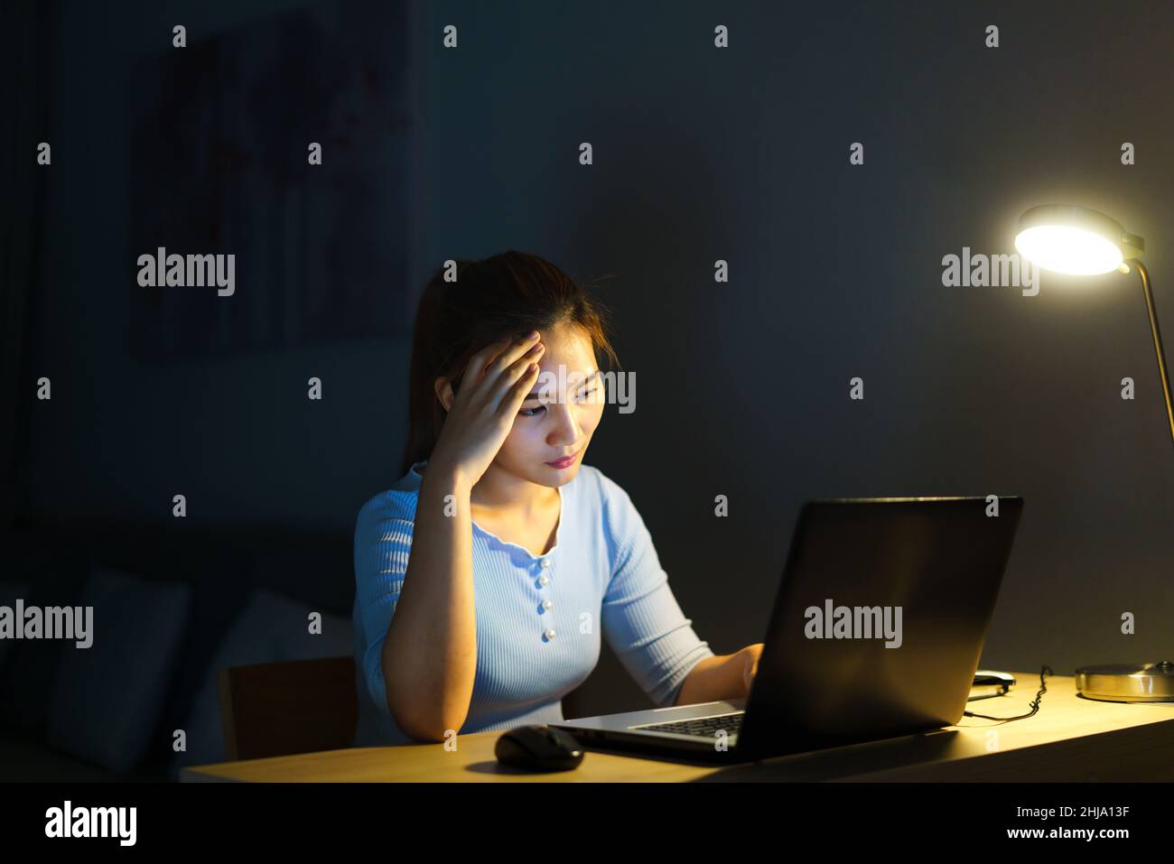 Donna asiatica lavoro a tarda notte stressante con i problemi di ricerca di progetto su un computer portatile o notebook a casa ufficio burnout sindrome concetto. Foto Stock