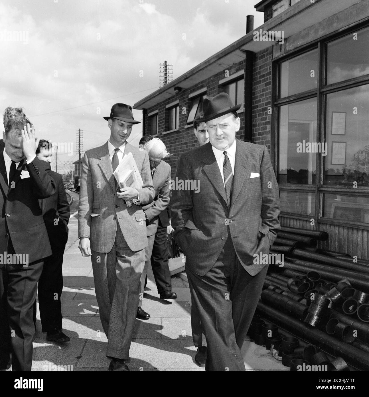 1963 Great Train Robbery fu la rapina di ¿milioni di 2,6 da un treno Royal Mail diretto da Glasgow a Londra sulla West Coast Main Line nelle prime ore del 8th agosto 1963, a Bridego Railway Bridge, Ledburn, vicino a Mentmore nel Buckinghamshire, Inghilterra. I nostri spettacoli di foto ... Il soprintendente Gerald McArthur di Scotland Yard (davanti, cappello) arriva sulla scena per esaminare il trasporto della posta nei sidings alla stazione ferroviaria di Cheddington, venerdì 9th agosto 1963. Foto Stock