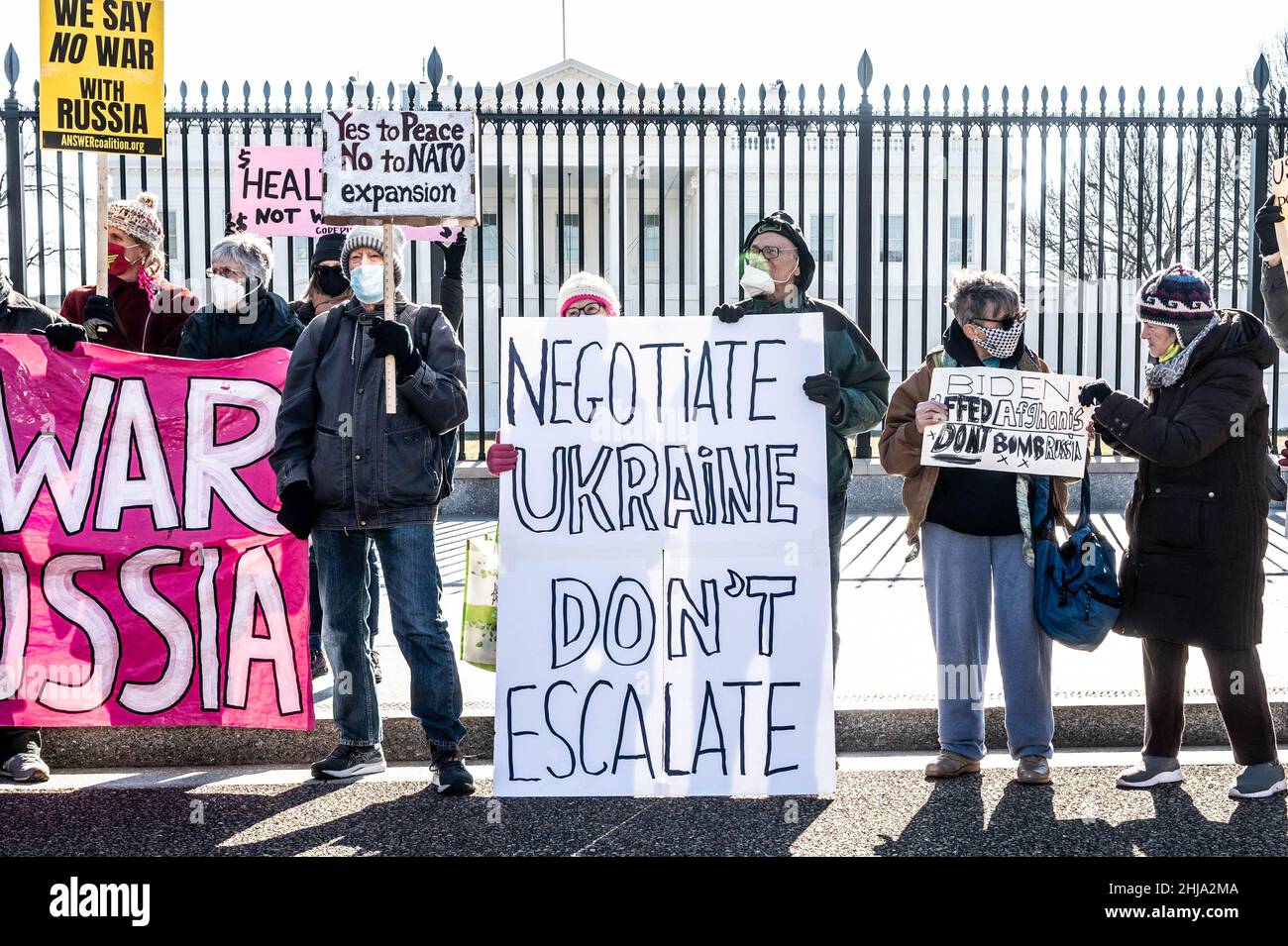 Un manifestante che ha in mano una bandiera che dice "negoziare l'Ucraina, non intensificare" in un raduno contro la guerra con la Russia sponsorizzato da più gruppi tra cui CODEPINK: Women for Peace, Black Alliance for Peace, ANSWER, e Maryland Peace Action alla Casa Bianca. Foto Stock