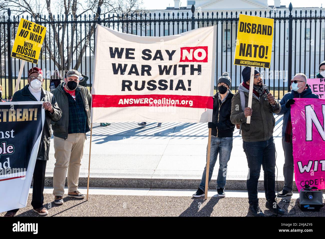 I manifestanti che hanno in mano una bandiera e cartelli che dicono "non diciamo guerra con la Russia” e "banda NATO!” In un raduno contro la guerra con la Russia sponsorizzato da diversi gruppi tra cui CODEPINK: Women for Peace, Black Alliance for Peace, ANSWER, e Maryland Peace Action alla Casa Bianca. Foto Stock