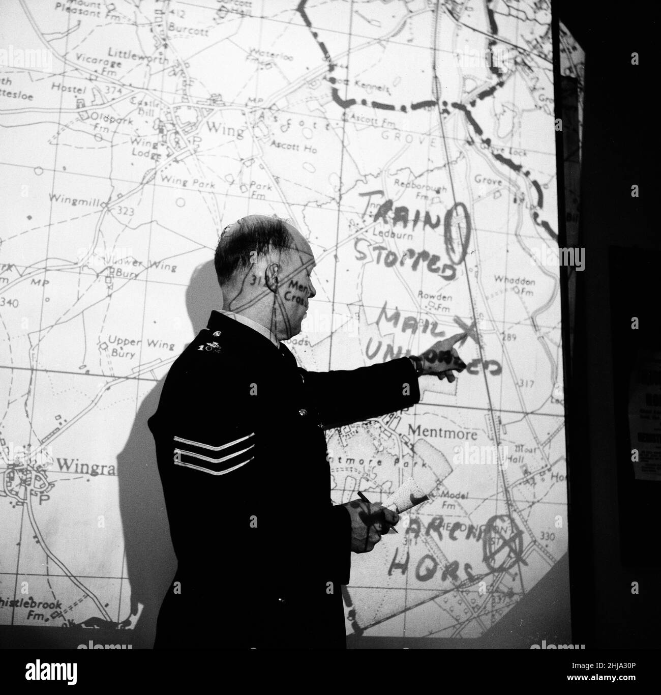 La sede centrale della polizia di Aylesbury, Buckinghamshire, all'interno della stanza di controllo della sede centrale della polizia come caccia al manhunt per il grande Gang della posta continua, lunedì 12th agosto 1963. La nostra immagine mostra ... mappa illuminata di scena rapina è proiettata su grande schermo. Il 1963 Great Train Robbery fu la rapina di £2,6 milioni da un treno Royal Mail diretto da Glasgow a Londra sulla West Coast Main Line nelle prime ore del 8th agosto 1963, a Bridego Railway Bridge, Ledburn, vicino Mentmore nel Buckinghamshire, Inghilterra. Foto Stock