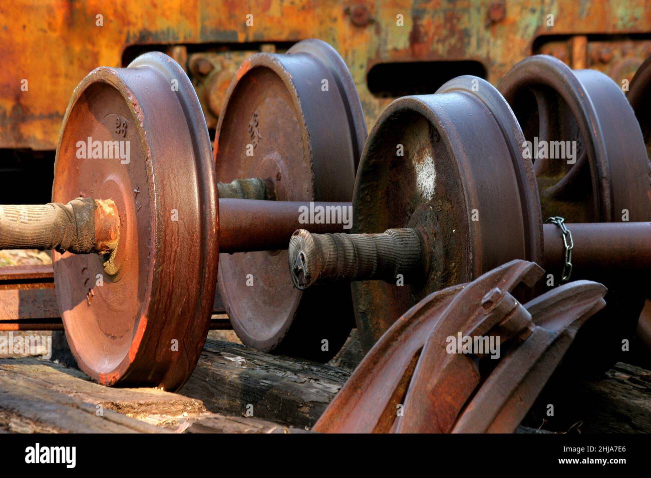 Grandi parti industriali in metallo arrugginito pesante con parete arrugginita Foto Stock