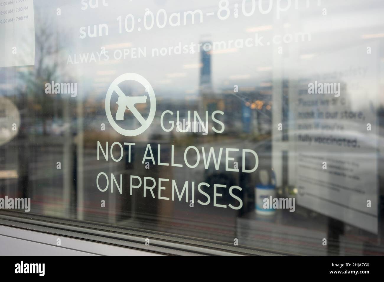 Il cartello di avvertimento "Guns Not Allowed on Premises" è visibile all'ingresso di un negozio Nordstrom rack a Portland, Oregon, venerdì 14 gennaio 2022. Foto Stock