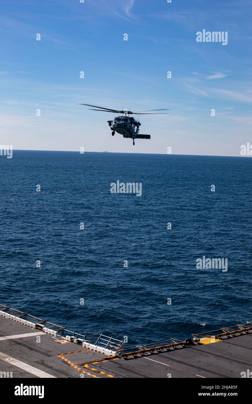 Una Marina degli Stati Uniti MH-60 Seahawk conduce operazioni di volo durante l'esercizio dell'unità di addestramento composita (COMPTUEX) a bordo della USS Kearsarge (LHD 3), 24 gennaio 2022. La Marine Expeditionary Unit 22nd e lo Squadrone anfibio (PHIBRON) sei sono in corso per COMPTUEX in preparazione di un prossimo dispiegamento. COMPTUEX è l’ultimo periodo in mare del programma di formazione pre-dispiegamento della MEU; mira a testare le capacità dell’ARG/MEU e a ottenere la certificazione di dispiegamento. (STATI UNITI Foto del corpo marino di Sgt. Armando Elizalde) Foto Stock