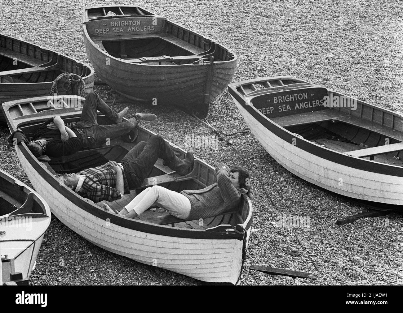 Scene di vacanza a Brighton godendo il sole estivo, gli operatori dei Brighton Deep Sea Anglers godono di un riposo nella loro barca prima di portare i turisti fuori per un viaggio veloce intorno alla baia. 7th luglio 1963 Foto Stock