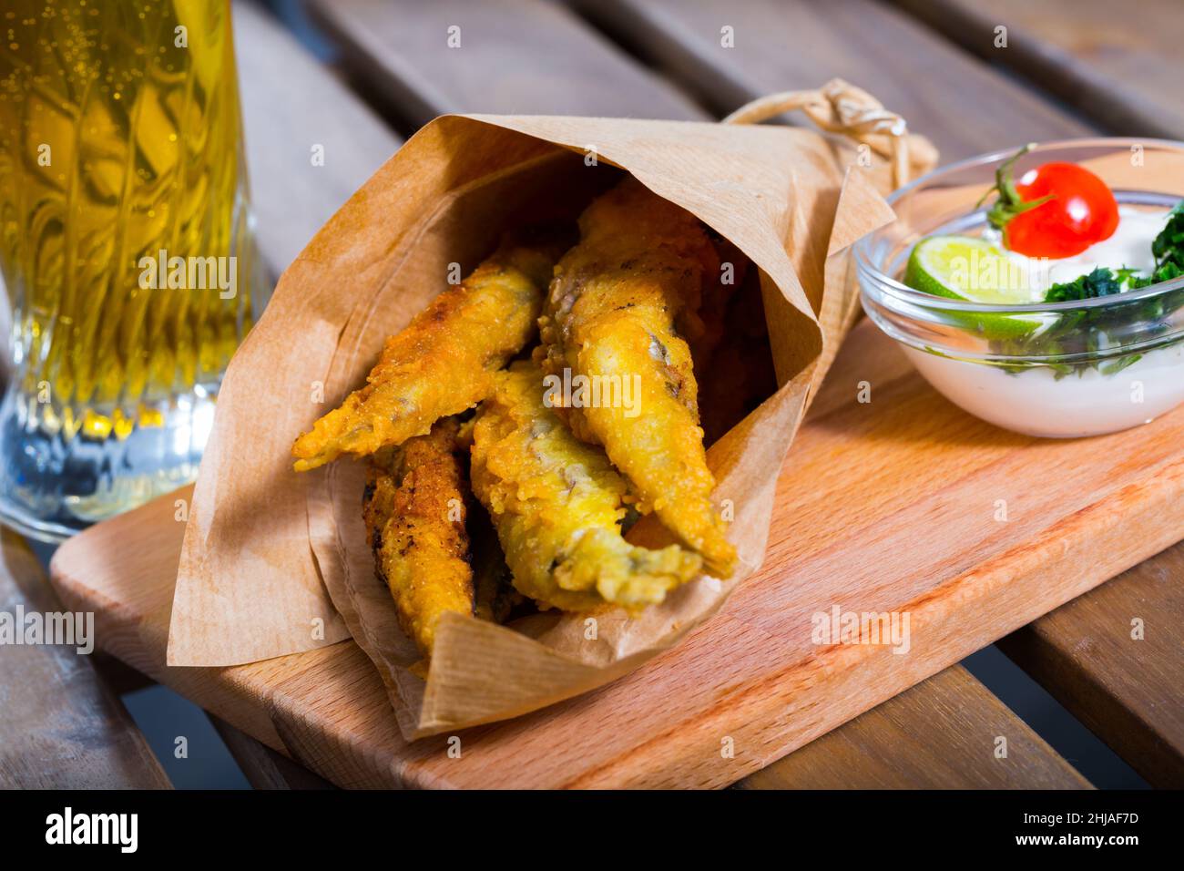 Acciughe fritte in padella con salsa cremosa al formaggio, verdure Foto Stock