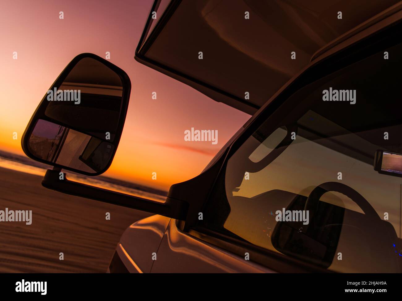Viaggio su strada in un veicolo da diporto. Classe C Overhead Bunk Motorhome RV Beach Sunset Camping Concept. Camper Van Front Close Up. Colori caldi. RVing Th Foto Stock