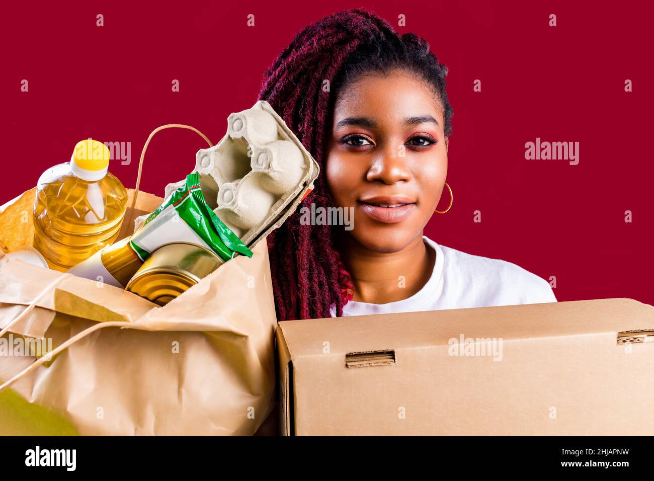 volontario ispanico americano che sostiene il concetto di donazione di cibo Foto Stock