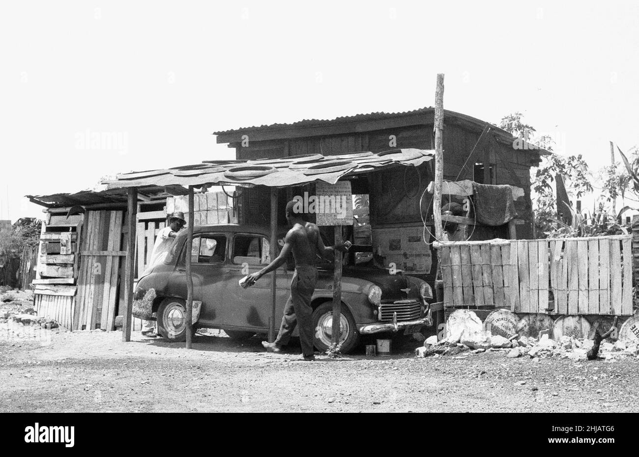 Un Morris Oxford in fase di riparazione in un garage auto al largo della Spanish Town Road, Kingston, Giamaica/ 19th maggio 1963 Foto Stock