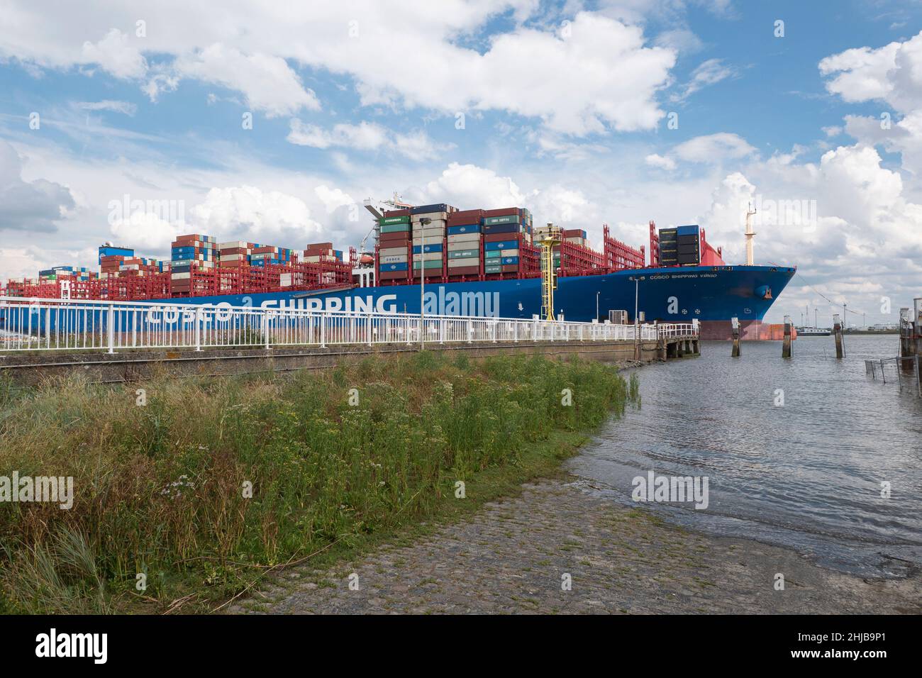 Doel, Belgio, 17 agosto 2020, la nave Container Cosco Shipping da Hong Kong, naviga molto vicino al molo del villaggio polder di Doel in Belgiu Foto Stock