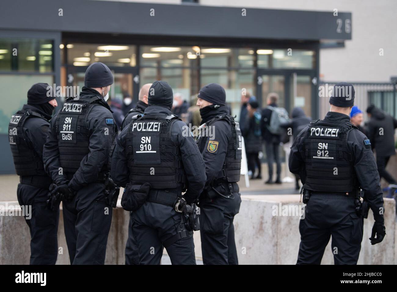 Dresda, Germania. 28th Jan 2022. I giornalisti attendono dietro gli ufficiali di polizia di fronte all'edificio del processo della Corte Regionale - una sala speciale della Corte Regionale superiore di Dresda - per l'ammissione. Più di due anni dopo il furto del gioiello dalla storica Green Vault di Dresda, inizia il processo di sei presunti autori. Credit: Kahnert/dpa-Zentralbild/dpa/Alamy Live News Foto Stock