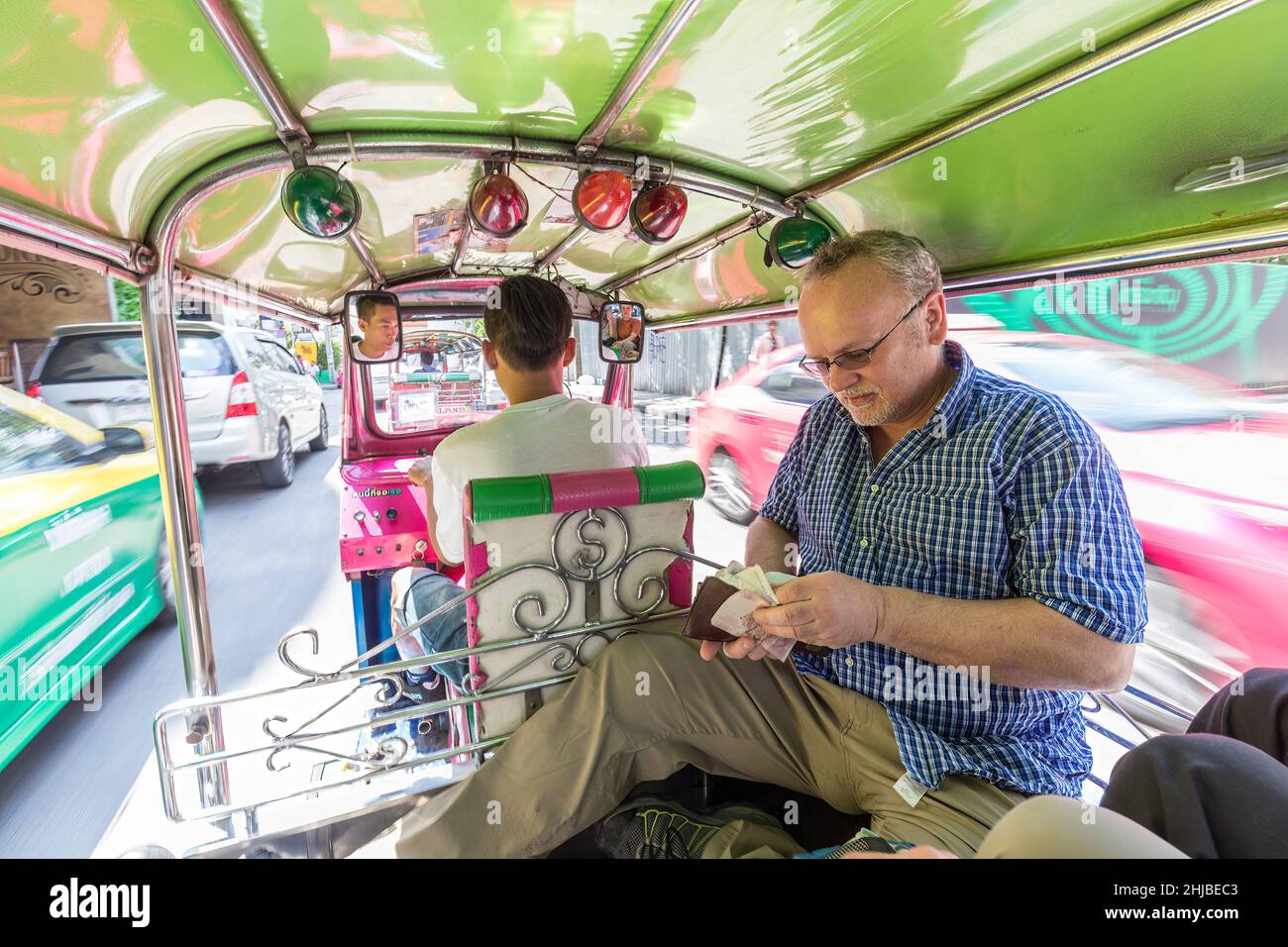 Turista in tuk tuk che controlla il denaro nel portafoglio durante il viaggio attraverso Bangkok, Thailandia Foto Stock