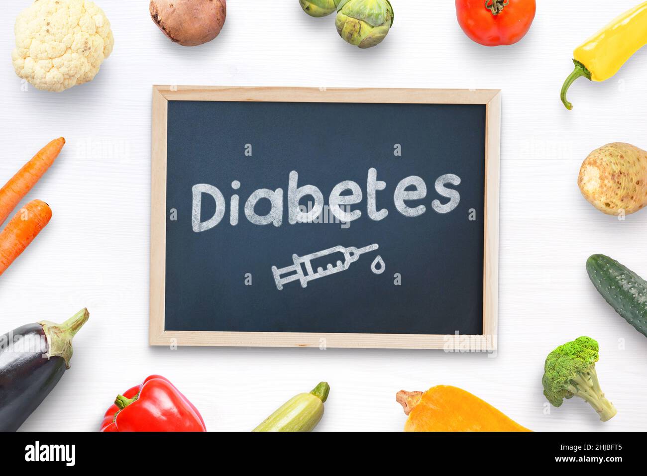Composizione del concetto di diabete con lavagna al centro con testo e disegno di iniezione di insulina circondato da cibo sano, verdure Foto Stock