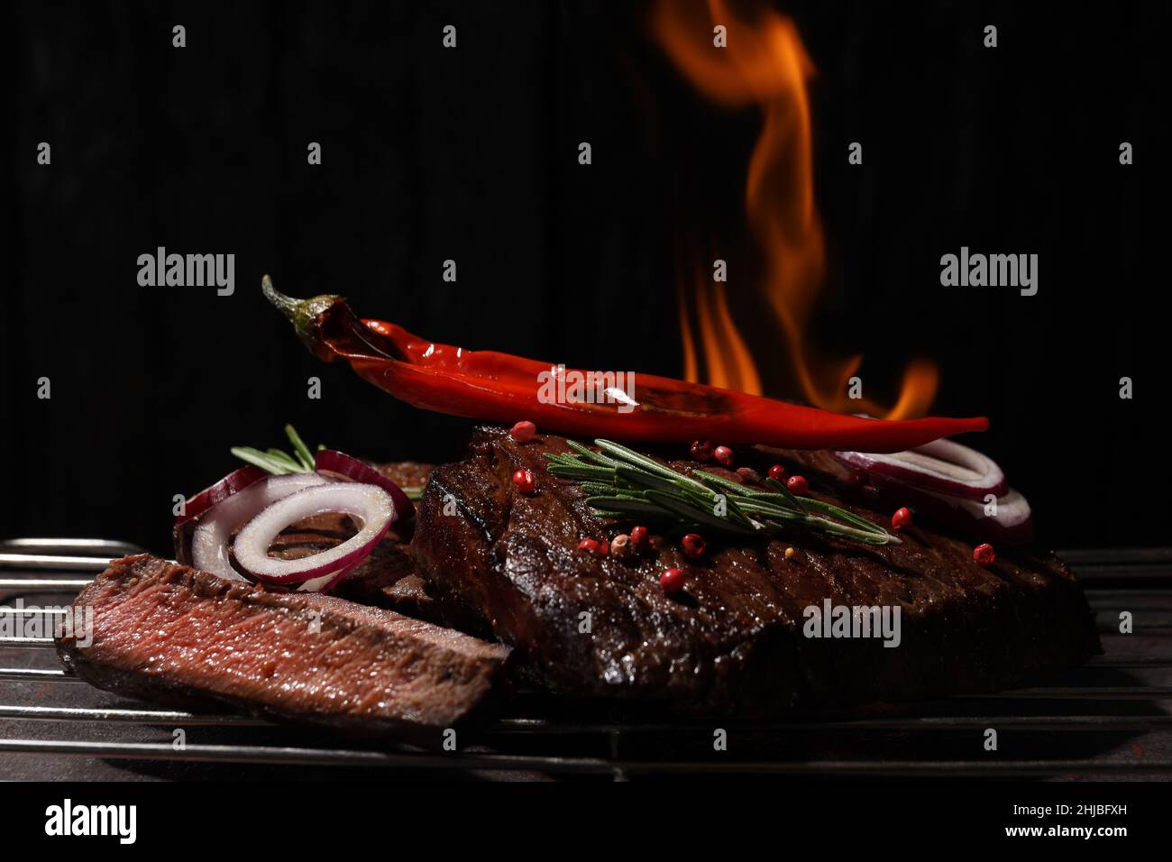 Concetto di cibo gustoso con bistecche di manzo su sfondo scuro Foto Stock